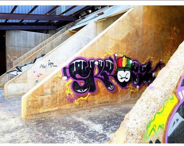 Dready graffiti piece under a concrete bridge