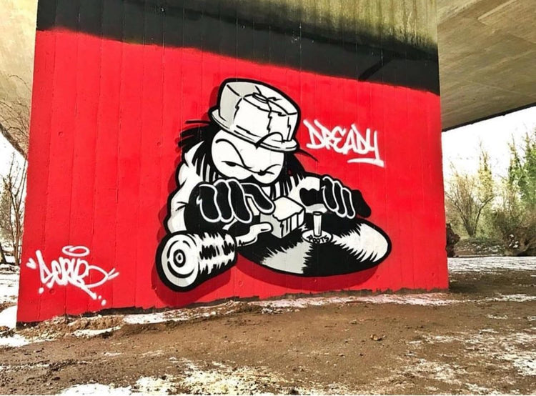 Dready DJ character painted on a red wall