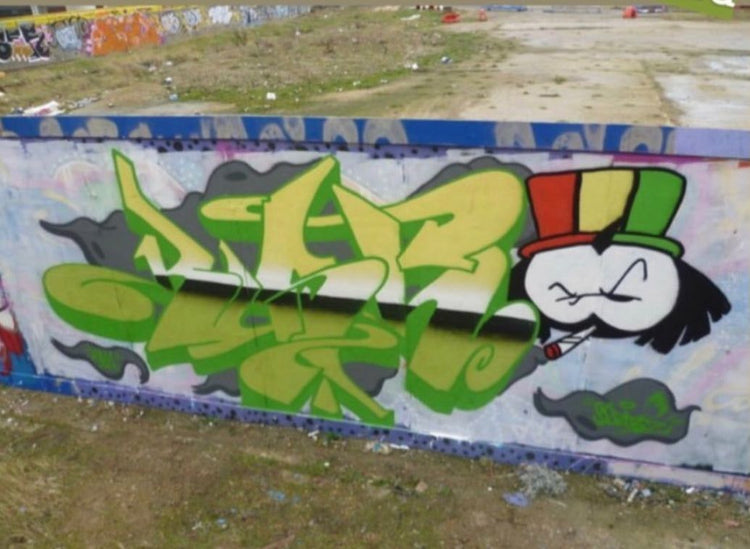 Green and Rasta-colour Dready piece on a low wall