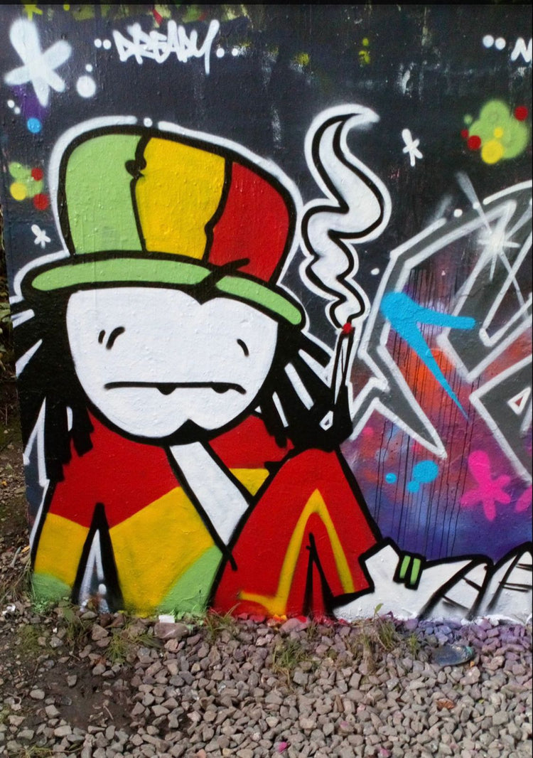 Dready character with Rasta hat on a graffiti wall